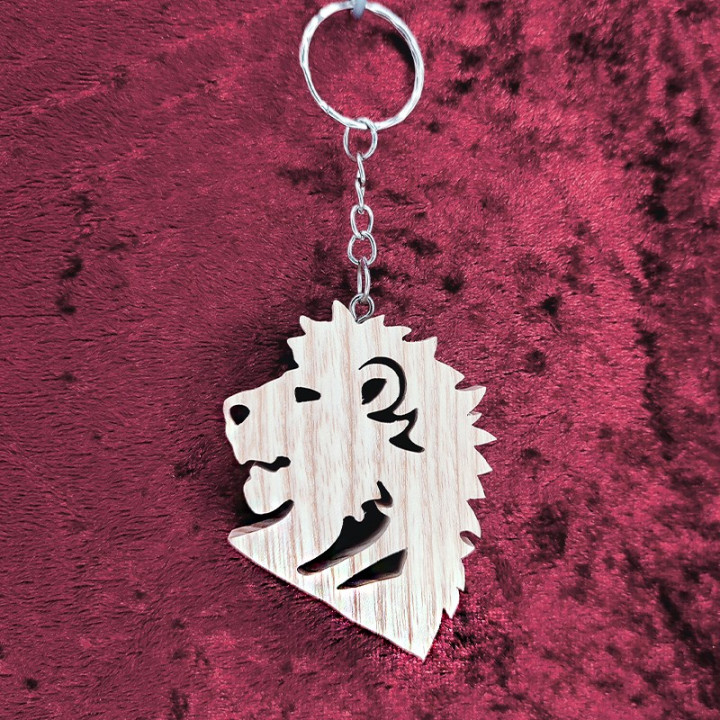 Voici un joli porte-clés d’une magnifique tête de lion en bois noble
