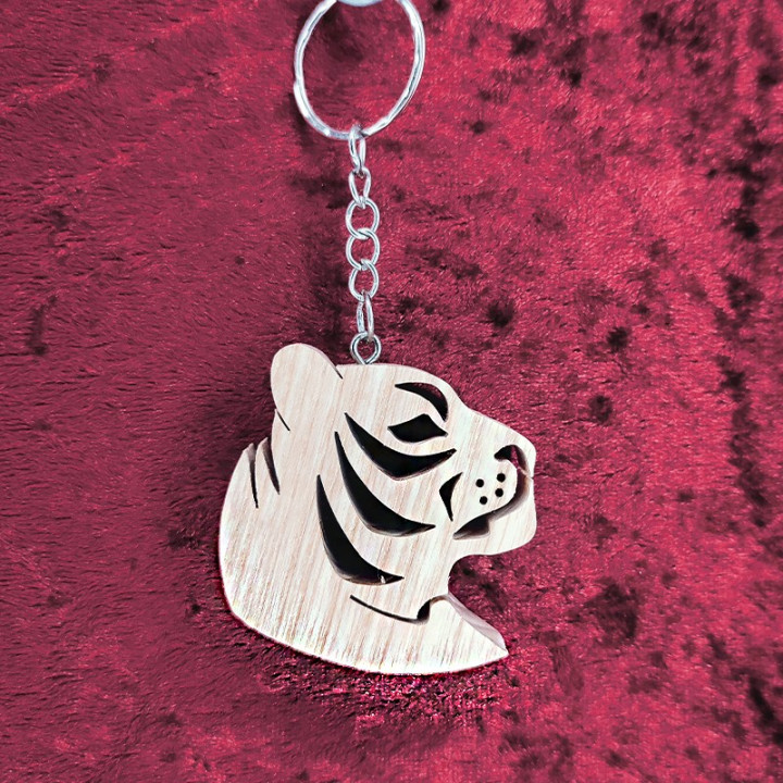 Voici un joli porte-clés d’une magnifique tête de tigre en bois noble