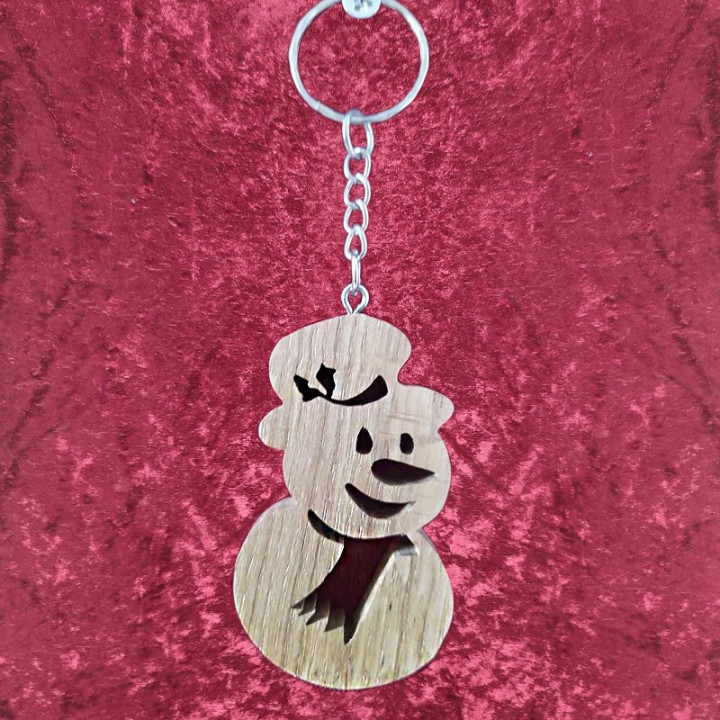 Voici un joli porte-clés d’un bonhomme de neige en bois noble