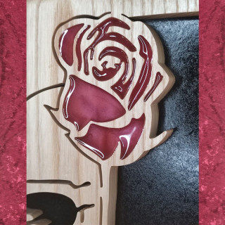 Tableau en bois noble d’une tête de mort avec une rose rouge