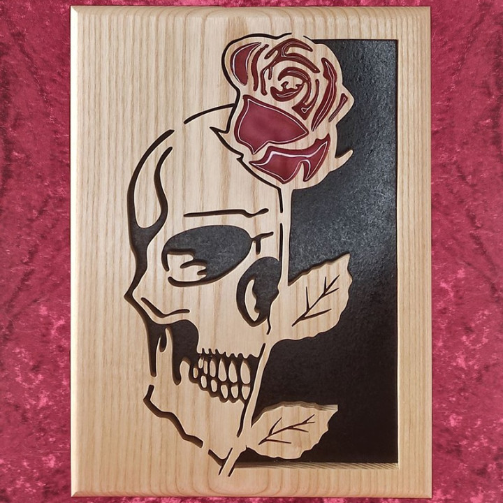 Tableau en bois noble d’une tête de mort avec une rose rouge