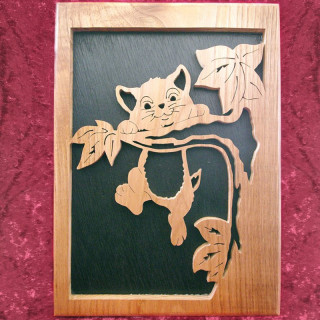 Tableau en bois noble d'un joli chaton percher sur une branche
