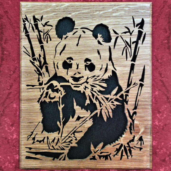 Tableau en chêne d'un panda assis qui mange du bambou