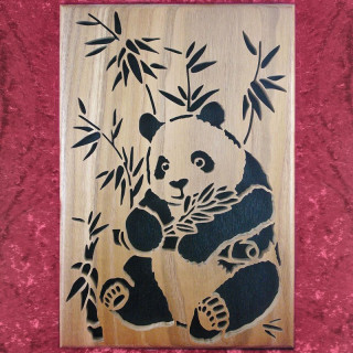 Tableau en bois noble d'un panda avec une branche de bambou