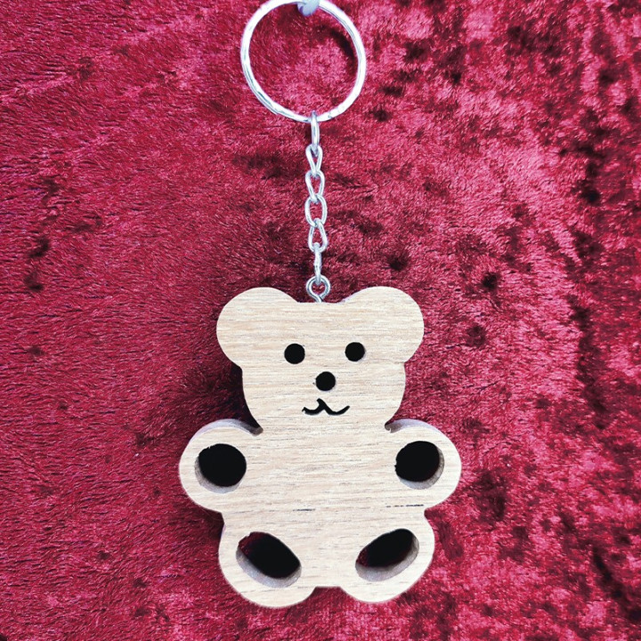 Voici un joli porte-clés ourson en bois noble