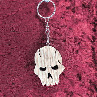Voici un joli porte-clés tête de mort en bois noble