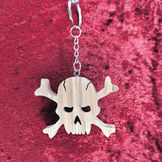Voici un joli porte-clés tête de mort avec os en bois noble