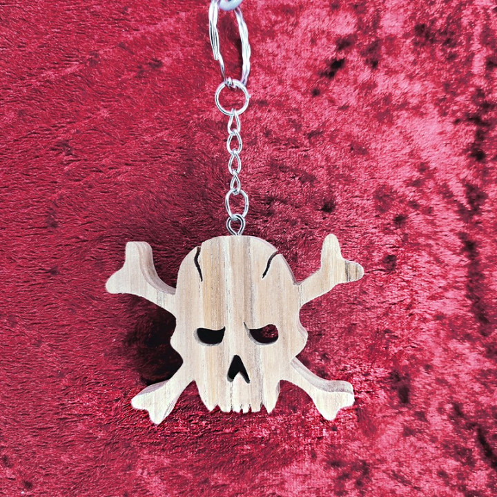 Voici un joli porte-clés tête de mort avec os en bois noble